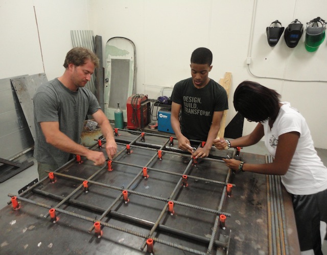 Eric Wandmacher and Studio H students Kerron-Hayes and Alexia-Williams construct a portion of the base for the Windsor Farmers Market pavilion in "If You Build It."