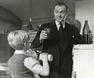Phillipe (Bobby Henrey) shares a glass of pop with Baines (Sir Ralph Richardson) in "The Fallen Idol."